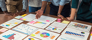 Person assessing several graphs, charts and information