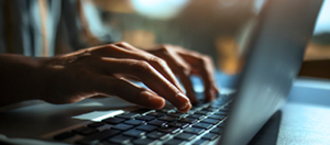 hands typing on laptop